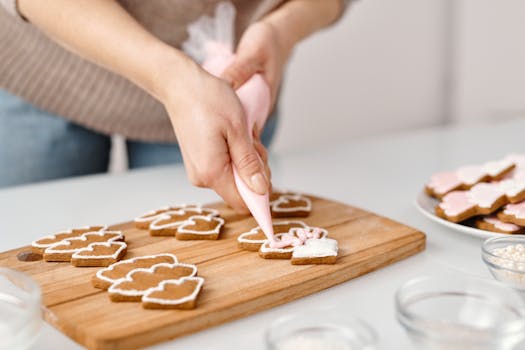 A person decorating festive Christmas cookies with icing, enhancing holiday spirit.